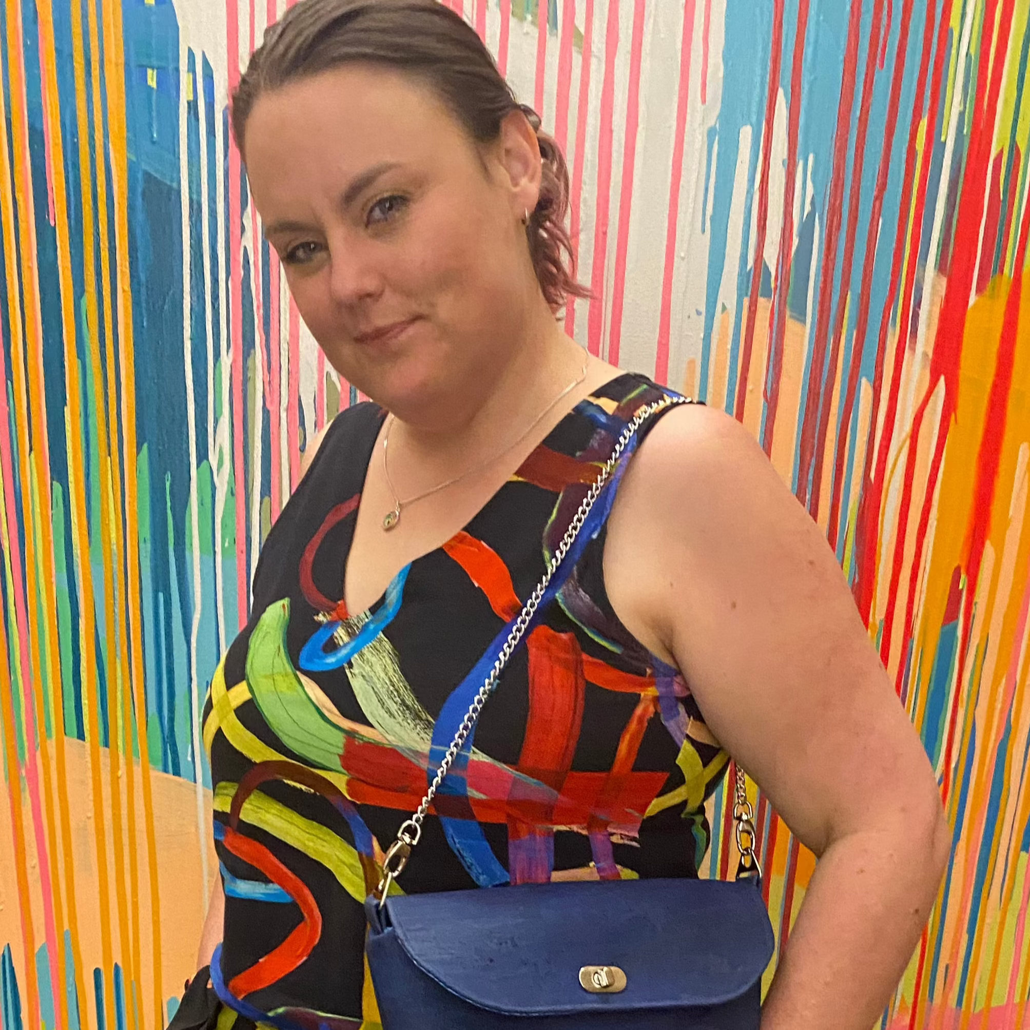 Megan stands in front of an abstract background