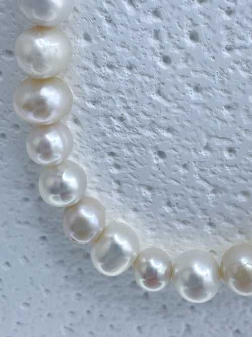 Close up on white pearls within iridian's bold white 9mm pearl and steel necklace 