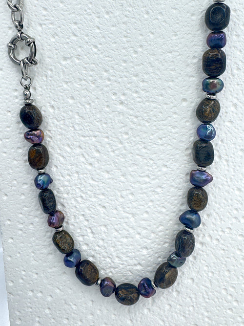 Medium close up on iridian's bronzite and purple pearl necklace on a white bust