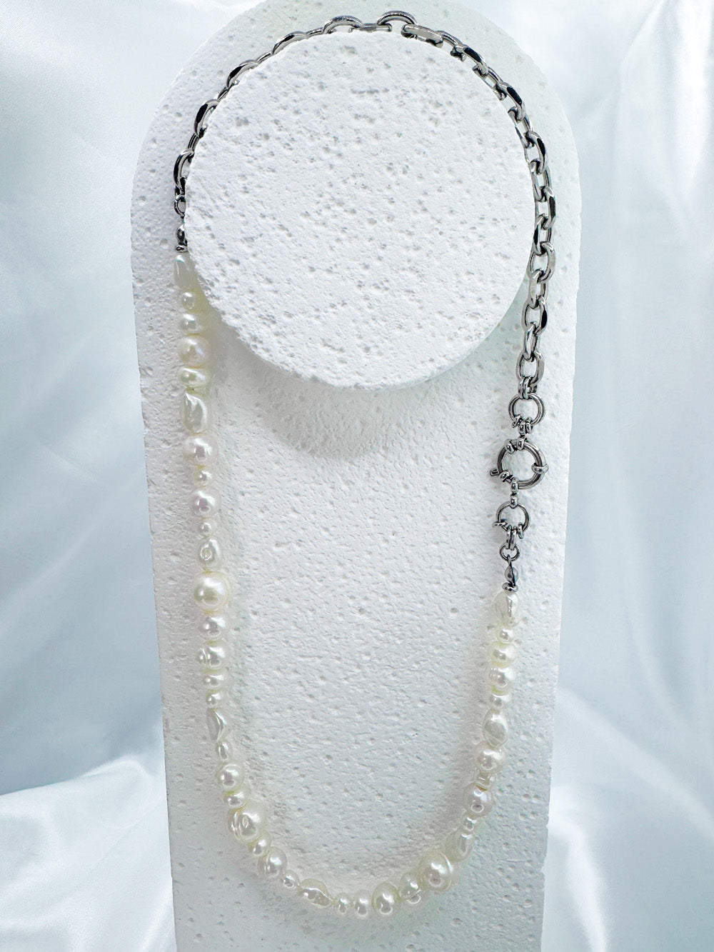 Full view of iridian's eclectic white pearl and steel necklace on a white display bust