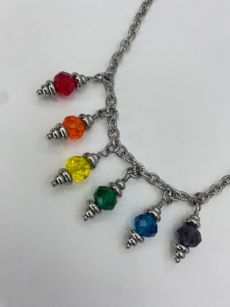 close-up on crystal rainbow glass bead charms on a necklace on white background