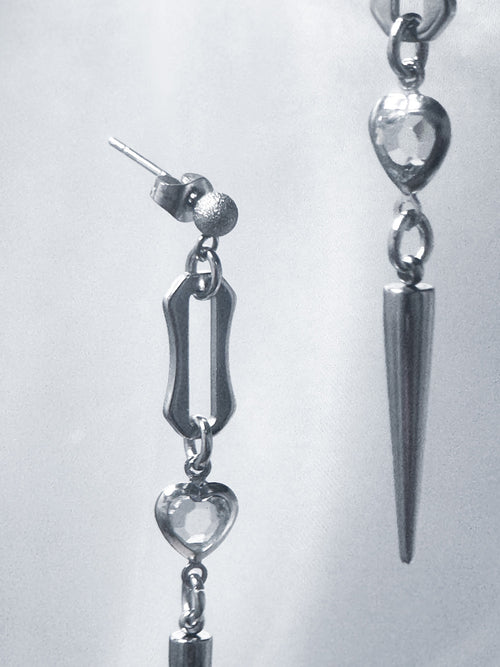 iridian design's crystal heart spiked stud earrings floating to create an abstract, artistic pattern