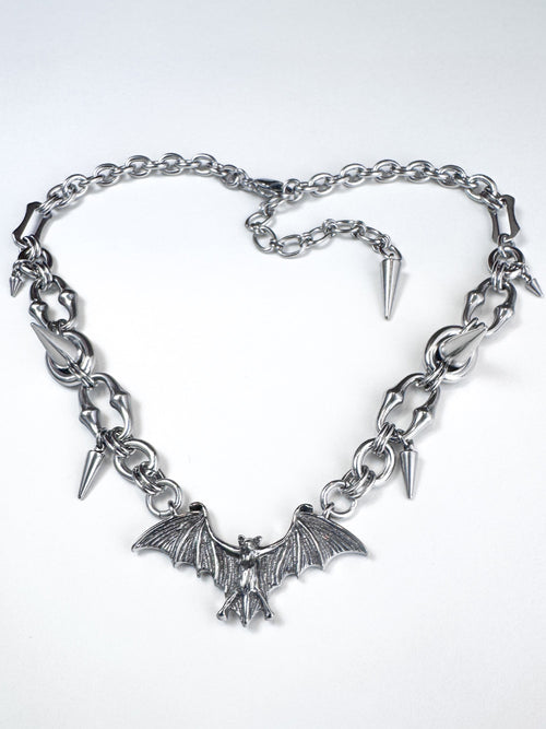 Iridian design's stainless steel bat pendant and spike necklace laid out in a heart shape