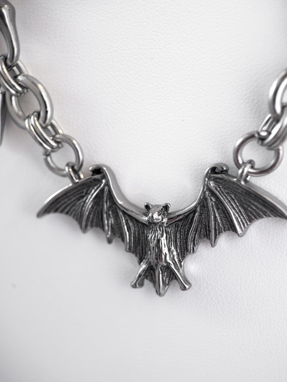 close up on pendant on iridian design's stainless steel bat and spike necklace