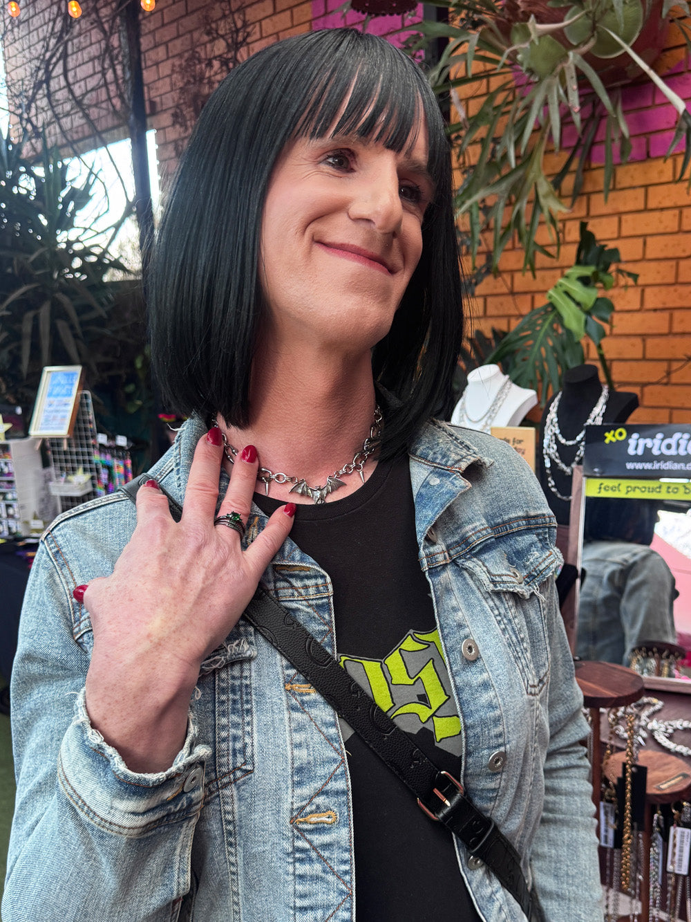 A woman wears iridian design's stainless steel bat pendant and spike necklace