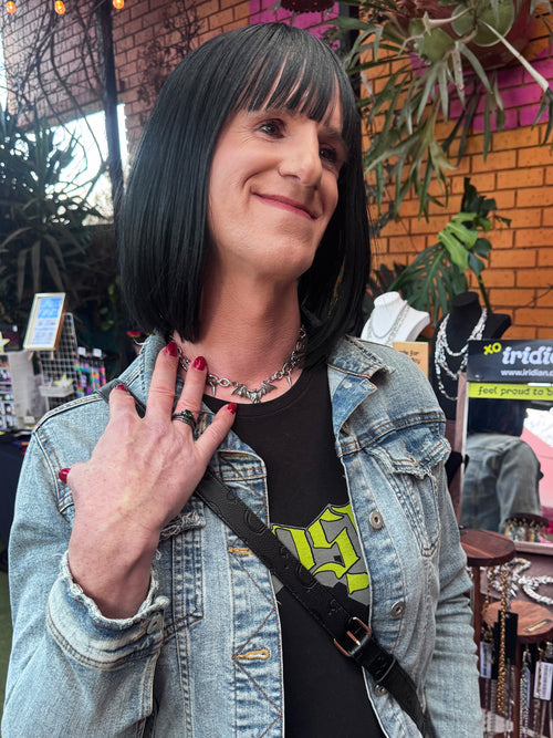 A woman wears iridian design's stainless steel bat pendant and spike necklace
